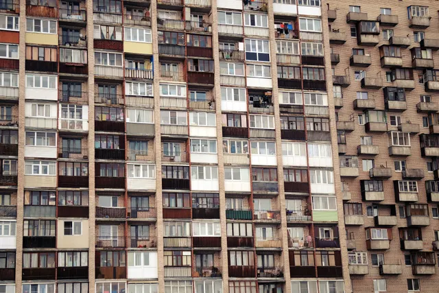 Multi-story apartment building facade with balconies and rows of windows.