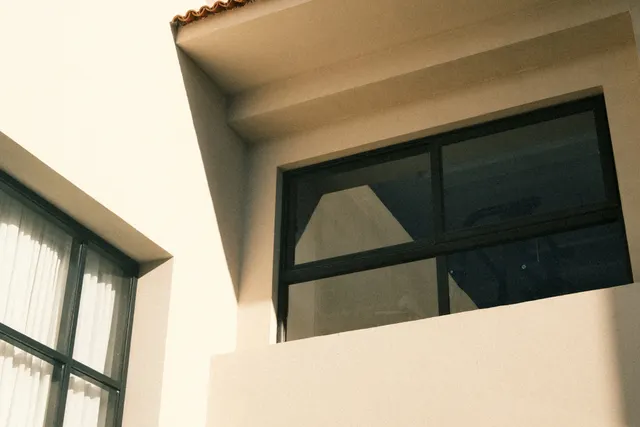 Contemporary property exterior with windows and a roof overhang.